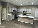 Spacious kitchen with gray cabinets, stainless steel appliances, and large white quartz island at 40816 W Sunland Dr, Maricopa, AZ 85138