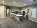 Open-concept living space featuring a kitchen with a large island and wood-look flooring throughout at 40816 W Sunland Dr, Maricopa, AZ 85138
