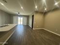 Open-concept living room featuring wood-look tile flooring and recessed lighting at 40816 W Sunland Dr, Maricopa, AZ 85138