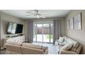 Cozy living room with a ceiling fan, large sliding glass doors that provide natural light, and comfortable seating at 40816 W Sunland Dr, Maricopa, AZ 85138