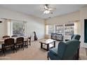 Bright living room boasts large windows, neutral carpeting, ceiling fan, and traditional furnishings at 44421 N 12Th St, New River, AZ 85087