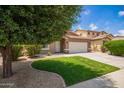 Charming single-story home with lush green lawn, Southwestern architecture, and desert landscaping for a serene aesthetic at 45309 W Gavilan Dr, Maricopa, AZ 85139