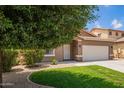 Beautiful single-story home featuring a lush lawn, mature trees, and classic Southwestern architecture with desert landscaping at 45309 W Gavilan Dr, Maricopa, AZ 85139