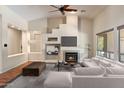 Bright living room with a fireplace, ceiling fan, and large windows, offering a comfortable and stylish space at 6438 E Claire Dr, Scottsdale, AZ 85254