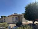 Well-maintained home with desert landscaping, mature trees, and a two-car garage with a charming tile roof at 8927 W Paradise Dr, Peoria, AZ 85345