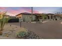 Beautiful exterior of a desert home with a paver driveway, xeriscaping, and a gated entrance at 9456 E Sands Dr, Scottsdale, AZ 85255