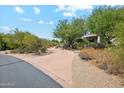 Long driveway leads to the home and is lined with desert vegetation at 10040 E Happy Valley Rd # 243, Scottsdale, AZ 85255