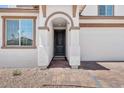 Inviting home entrance featuring a dark front door, a brick walkway, and an attached two-car garage at 10860 E Tiburon Ave, Mesa, AZ 85212