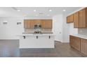 Open-concept kitchen with wooden cabinets, stainless steel appliances, a large island, and modern countertops at 10860 E Tiburon Ave, Mesa, AZ 85212