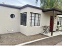 Unique house exterior with dark framed windows, red door, and small seating area at 1117 W Glenrosa Ave, Phoenix, AZ 85013
