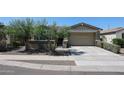 Charming single-story home featuring desert landscaping, a two-car garage, and a welcoming walkway at 16930 W Woodlands Ave, Goodyear, AZ 85338