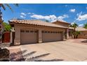 Spacious three-car garage with tan exterior, tile roof, and ample parking space on a sunny day at 1884 E Stephens Dr, Tempe, AZ 85283