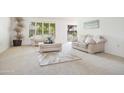 Bright living room featuring neutral carpet, two sofas, and a large window at 19030 N Signal Butte Cir, Sun City, AZ 85373
