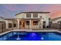 A serene backyard featuring a sparkling pool, covered patio, and secure black metal fencing at 2556 E Quiet Hollow Ln, Phoenix, AZ 85024