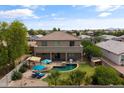 Aerial view of a fenced backyard with a pool, patio, lounge area, grassy area, and mature trees at 35952 W Catalonia Dr, Maricopa, AZ 85138