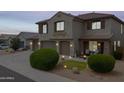 Charming two-story home with three-car garage, manicured landscaping, stone accents, and a cozy covered front porch at 35952 W Catalonia Dr, Maricopa, AZ 85138