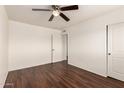 Bedroom with dark wood floor, ceiling fan, and a double door closet at 4802 W Hayward Ave, Glendale, AZ 85301
