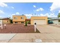 Charming two-story tan home with a two-car garage and desert landscaping at 4802 W Hayward Ave, Glendale, AZ 85301