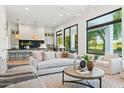Bright, open living room connected to a modern kitchen, featuring light wood floors and large windows at 8196 E Sunnyside Dr, Scottsdale, AZ 85260
