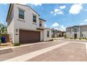 View of a home's exterior with a brown garage door, a view of the street, and some landscaping at 9901 E Tamery Ave, Mesa, AZ 85212
