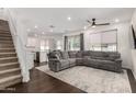 Open-concept living space with a large grey sofa and a staircase visible from the living area at 9901 E Tamery Ave, Mesa, AZ 85212