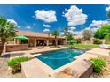 Luxurious backyard featuring a sparkling pool, bar area, and lush landscaping, perfect for outdoor entertaining and relaxation at 10105 E Larkspur Dr, Scottsdale, AZ 85260