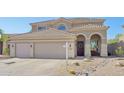 Home with tile roof features an arched entryway and three-car garage at 10448 E Conieson Rd, Scottsdale, AZ 85255
