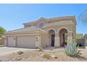 Home with tiled roof featuring arched entry and desert landscaping at 10448 E Conieson Rd, Scottsdale, AZ 85255