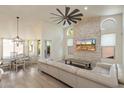Bright living room with a decorative stone accent wall, large windows, and a comfortable white sofa at 13361 N 99Th Pl, Scottsdale, AZ 85260