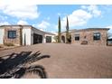 Beautiful home with stone accents, stucco exterior, and three-car garage complemented by lush desert landscaping at 13648 E Aloe Vera Dr, Scottsdale, AZ 85262