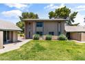 Inviting townhouse with green lawn, shrubs, and sidewalk under a partly cloudy sky at 18206 N 45Th Ave, Glendale, AZ 85308