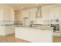 Modern kitchen featuring white cabinetry, stainless steel appliances, and granite countertops at 1903 E Empeltre Rd, San Tan Valley, AZ 85140