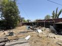 Untidy backyard filled with debris, exposed roofing, and building materials at 2030 N 21St Pl, Phoenix, AZ 85006