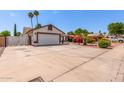 Spacious driveway leading to a well-maintained home with vibrant landscaping and desert-friendly yard at 2230 N Los Alamos --, Mesa, AZ 85213