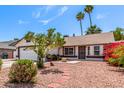 Inviting home exterior with neat landscaping, including palm trees, bougainvillea, and decorative stone at 2230 N Los Alamos --, Mesa, AZ 85213