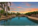 Inviting backyard pool featuring a rock waterfall, lush greenery, and a serene atmosphere, perfect for relaxation at 22737 N Sunset Dr, Maricopa, AZ 85139