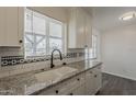 Kitchen sink with granite countertops, white cabinets and plenty of natural light at 3202 W Glenrosa Ave, Phoenix, AZ 85017