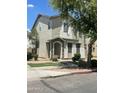 Two-story home featuring a stucco exterior, a stone-accented entrance, and shade trees at 6614 W Polk St, Phoenix, AZ 85043