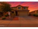 Charming two-story home with desert landscaping, brick accents, and a two-car garage against colorful dusk sky at 6632 W Saguaro Park Ln, Glendale, AZ 85310
