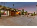 View of a covered carport with wooden beam details, and a landscaped front yard at 6932 E Latham St, Scottsdale, AZ 85257
