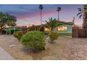 Charming single-story home with desert landscaping and palm trees at dusk at 6932 E Latham St, Scottsdale, AZ 85257