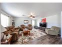 Spacious living room with hardwood floors, fan, and comfortable seating arrangements at 8943 W Sierra Vista Dr, Glendale, AZ 85305