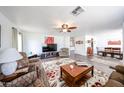 Open-concept living room featuring hardwood floors, ceiling fan, and modern furnishings at 8943 W Sierra Vista Dr, Glendale, AZ 85305