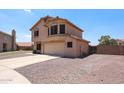 Stucco home with a two-car garage, desert landscaping, a side gate and an open backyard at 9243 W Palmer Dr, Peoria, AZ 85345
