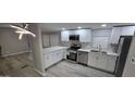 Updated kitchen features stainless appliances, white cabinets, and marble countertops at 9632 E Arbor Cir, Mesa, AZ 85208
