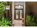Grand entryway features a custom double door with modern design elements and stylish overhead lighting at 9675 E Roadrunner Dr, Scottsdale, AZ 85262