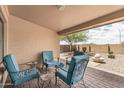 Cozy covered patio features brick floors, comfortable seating, and views of the desert landscape at 10940 E Olla Ave, Mesa, AZ 85212