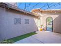Enclosed courtyard is beautifully decorated with decorative wall art, string lights and an archway at 1128 E Phelps St, Gilbert, AZ 85295