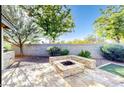 Backyard features an outdoor fire pit with built-in seating, desert landscaping, and a synthetic grass area at 13280 W Caribbean Ln, Surprise, AZ 85379