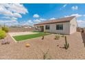 Spacious backyard with desert landscaping, artificial grass, covered patio, and block fencing, perfect for outdoor living at 17886 W Brookwood Dr, Goodyear, AZ 85338